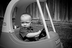 Photograph of baby boy in a toy car